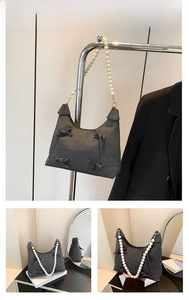 Detail of grey denim tote bag with large pearl strap and decorative bow accents