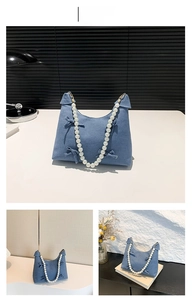 Close-up of light blue handbag with 3D bows and elegant white pearl beaded shoulder strap