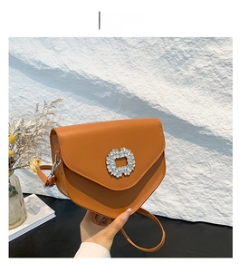 Détail du sac à main marron avec boucle en strass tournesol et bandoulière en cuir