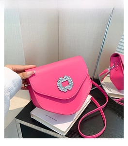 Détail du sac à main triangulaire rose fuchsia avec boucle en strass et bandoulière
