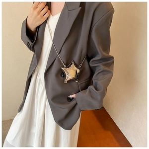 Star-shaped silver crossbody bag shown on a model with sleek metal chain strap