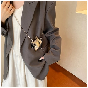 Close-up of a silver star-shaped clutch bag with reflective mirror finish and chain strap