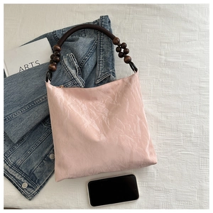 Pink velvet hobo bag with unique wooden bead handle and brown rope strap detail