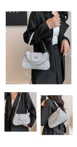 Detail of grey marble pattern handbag featuring a decorative metal butterfly buckle