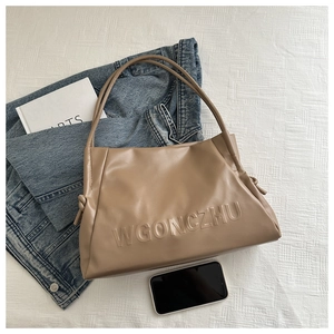 Dettaglio della borsa tote in morbida pelle kaki con logo impresso e nodi laterali