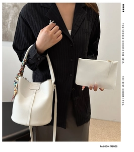 Detail of white lychee pattern bucket bag with fashion embossing and colorful silk scarf