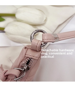 Detail of pink leather bag showing the detachable silver metal ring and zipper closure