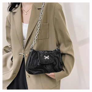 Detail of silver butterfly buckle and marble pattern on black crescent shoulder bag