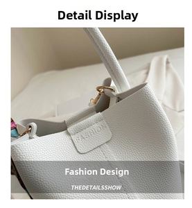 Close-up of white lychee texture leather handbag with gold D-ring and fashion engraving