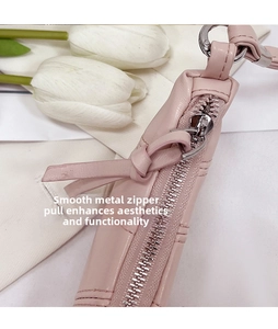 Macro shot of polished gold-tone metal zipper on high-quality pink leather handbag
