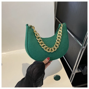 Detail van groene halve maantas met krokodillenstructuur en gouden ketting