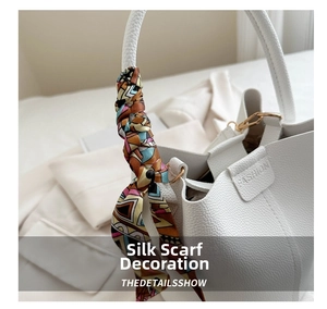 Detail of white lychee leather bucket bag with colorful geometric silk scarf handle decoration