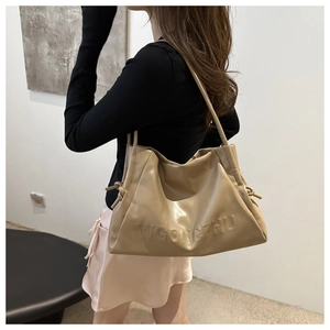 Dettaglio della borsa tote in pelle beige con scritta WGONGZHU a rilievo e coulisse
