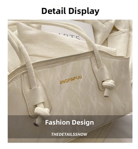 Gros plan du sac beige à texture marbrée avec logo doré et détails de nœuds élégants