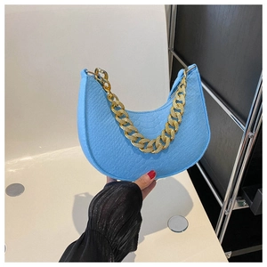 Detail van hemelblauwe hobo-tas met reliëfleer en dikke gouden metalen kettinggreep