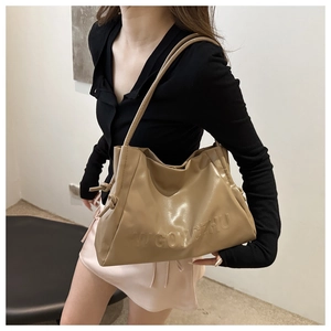Dettaglio della borsa tote in pelle kaki con pieghe morbide e scritte in rilievo eleganti