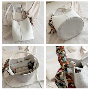 Detailed view of white lychee leather bucket bag with silk scarf handle and spacious interior