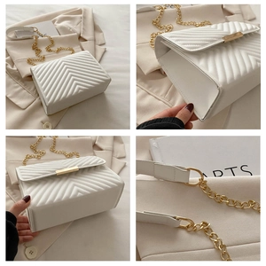 Detail view of white quilted crossbody bag with golden hardware and chain strap