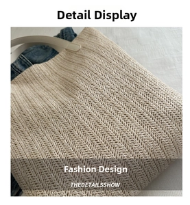 Detailed view of beige straw tote bag featuring twill weave texture and white leather handles