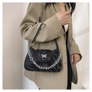 Détail du sac épaule noir à motif marbre avec boucle papillon argentée et grosse chaîne