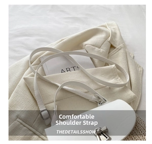 Detail of adjustable white leather shoulder strap with a silver metal buckle on a woven bag