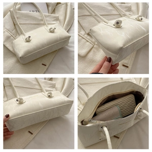 Vue détaillée du sac à bandoulière marbré blanc avec nœud et intérieur spacieux