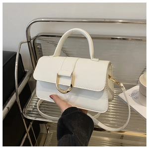 Dettaglio della borsa a mano bianca con chiusura a D dorata e texture in pelle liscia