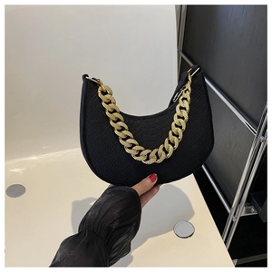 Detail van zwarte hobo tas met slangenreliëf en grove goudkleurige metalen ketting