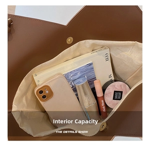 Internal view of brown tote bag with metal magnetic clasp showing spacious storage capacity
