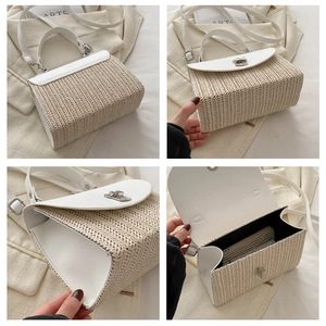 Detail view of woven straw crossbody bag featuring white leather flap and metal clasp closure