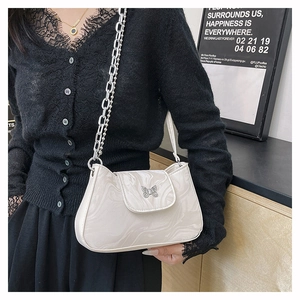 Détail du sac à bandoulière motif marbre avec boucle papillon et chaîne en métal argenté
