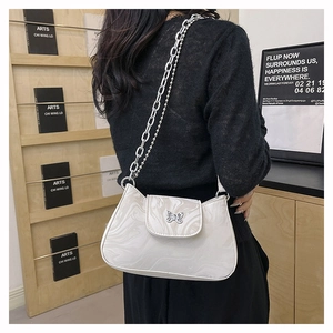 Detail of white marble texture underarm bag with silver butterfly clasp and chain strap
