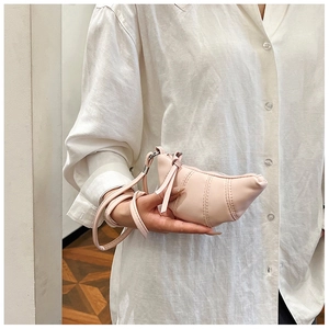 Detailed view of mini pink croissant neck bag with refined pleated leather texture