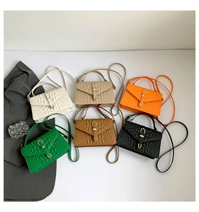 Flat lay of six mini croc-pattern handbags in multiple colors with gold hardware