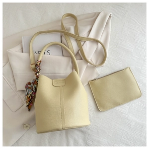 Detail der beigen Beuteltasche mit Litchi-Textur, Fashion-Prägung und Seidenschal-Deko