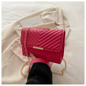 Detail showing fuchsia quilted leather texture and golden metal chain of the small bag