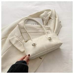 Détail du sac bandoulière blanc crème avec texture marbre et design élégant à nœud
