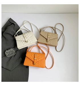 Detailed overhead view of mini croc-effect handbags in ivory, brown and orange colors