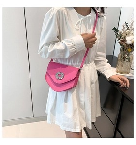 Détail du sac selle rose avec boucle florale en strass et fine bandoulière rose