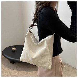 Detail of white hobo bag featuring retro dark wooden bead strap and pleated fabric texture