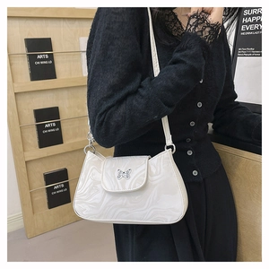 Détail de la boucle papillon argentée sur le sac à bandoulière effet marbre blanc