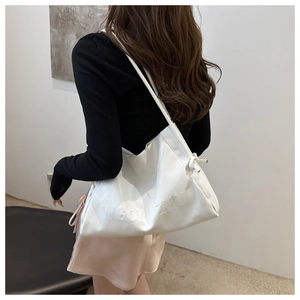Dettaglio della grande borsa a spalla bianca con logo WGONZHU a rilievo e morbida ecopelle