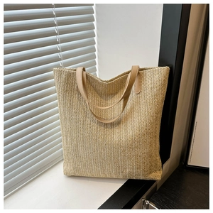 Detailed view of the V-shape woven texture and cream faux leather handles on a summer tote bag