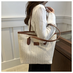 Detail of V-shaped woven straw texture with contrasting dark brown leather shoulder straps