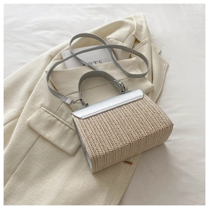 Detailed close-up of woven straw texture and silver metallic leather flap on crossbody bag