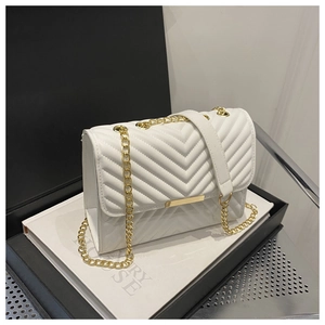 Detail of white V-quilted faux leather crossbody bag with gold chain and metal clasp