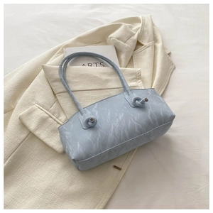 Vue détaillée du sac sous le bras bleu clair effet marbre avec nœud sur la bandoulière