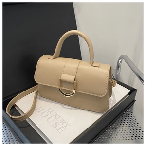 Dettaglio borsa beige in pelle con fibbia a D dorata e manico superiore elegante