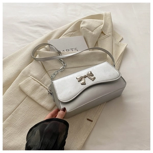 Detailed view of silver metallic PU square bag with elegant metal butterfly bow decoration