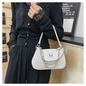 Détail du sac bandoulière marbré blanc avec papillon argenté et double chaîne de luxe